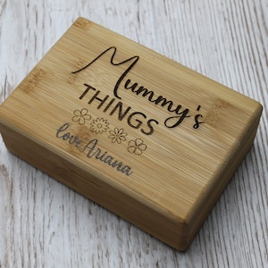 May include: A wooden box with the text "Mummy's Things" and "love Ariana" engraved on it. The box is decorated with small flower designs.