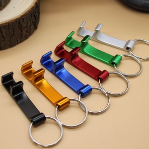 May include: Six different colored bottle openers with key rings. The colors are silver, green, red, blue, gold, and black.
