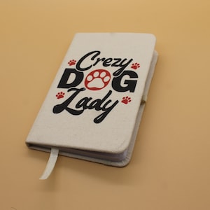 May include: A white canvas notebook with a black and red design that says "Crazy Dog Lady" with paw prints.