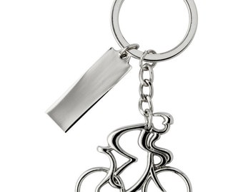 May include: Silver-toned keychain featuring a cyclist riding a bicycle. The keychain has a small rectangular tag attached to it.