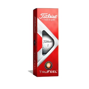 May include: A red box of Titleist TruFeel golf balls. The box features the Titleist logo and the text "#1 ball in golf". The box also shows a close-up of a white golf ball with the Titleist logo and the number "1" printed on it.