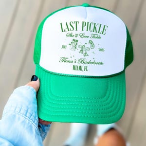 May include: A green and white trucker hat with the text "LAST PICKLE She'll Ever Tickle" in green. The hat also includes the text "July *2025" and "Fiona's Bachelorette MIAMI, FL".
