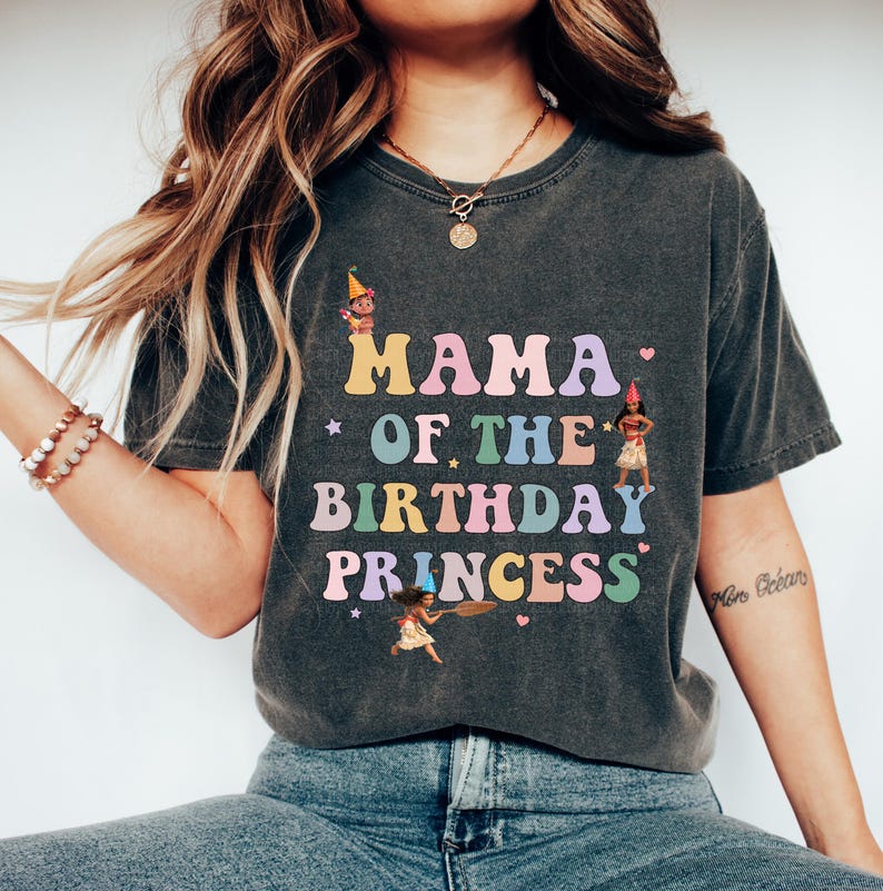 May include: A gray t-shirt with the text "Mama of the Birthday Princess" in rainbow colors. The text is surrounded by stars and hearts. There are cartoon images of princesses on the shirt.