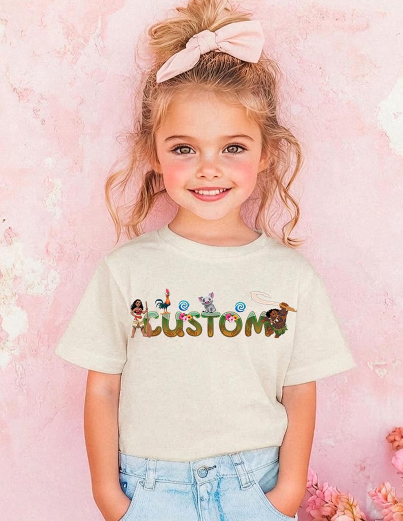 A young girl with a pink bow in her hair is smiling and wearing a white t-shirt with the word "CUSTOM" printed on it.