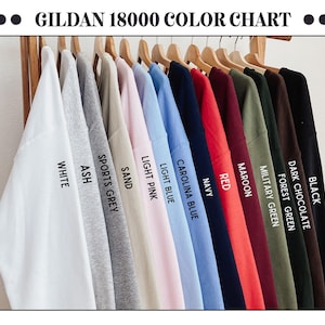 May include: Color chart for Gildan 18000 t-shirts, showing 12 different colors: Black, Dark Chocolate, Forest Green, Military Green, Maroon, Red, Navy, Carolina Blue, Light Blue, Light Pink, Sand, Sports Grey, Ash, and White.