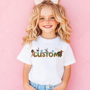 A young girl with curly blonde hair is smiling and wearing a white t-shirt with the word "CUSTOM" printed on it.