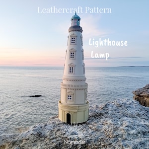Può includere: Una lampada a forma di faro in pelle bianca con la parte superiore verde, posizionata su una roccia con mare e cielo sullo sfondo. La lampada ha finestre e le scritte "Leathercraft Pattern" e "Lighthouse Lamp" sono visibili.