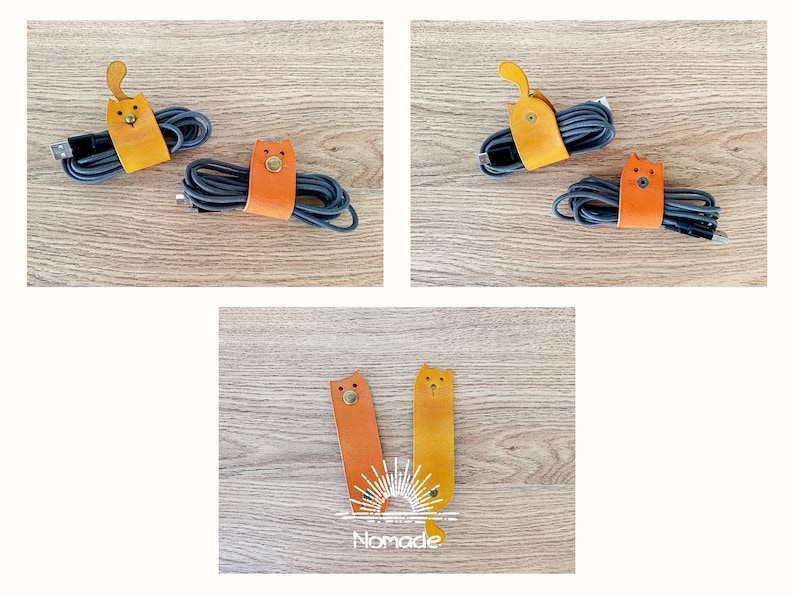 May include: Three leather cat-shaped cable organisers in orange and yellow. The organisers are on a wooden surface. The text "Nomade" is visible in the bottom centre of the image.