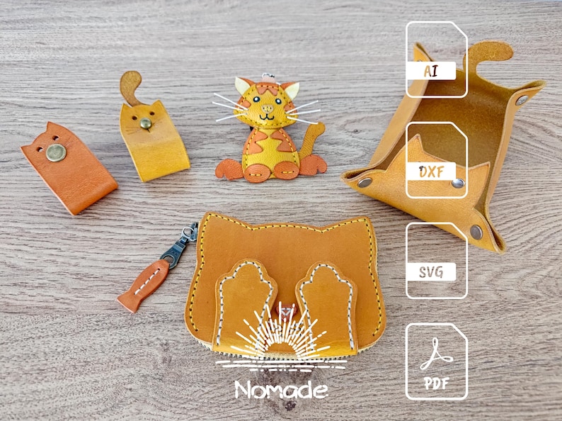 May include: A set of leather cat-shaped keychains and a small leather pouch. The keychains are orange and yellow with black eyes and whiskers. The pouch is brown with a cat face design and a zipper closure. The image also includes file format icons for AI, DXF, SVG, and PDF.