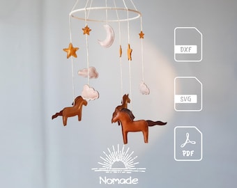 May include: A hanging mobile featuring brown horse figures, pale pink clouds, yellow stars, and a crescent moon suspended from a white circular frame. The image includes file icons labeled DXF, SVG, and PDF, along with the text Nomade at the bottom.