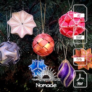 May include: Assortment of handmade Christmas ornaments in various shapes and colors, including a star, sphere, and teardrop. The ornaments are hanging on a green Christmas tree. The word "Nomade" is at the bottom of the image.