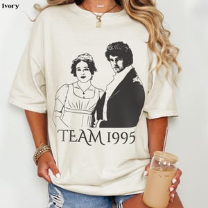 May include: A white t-shirt with a black and white illustration of two people and the text "TEAM 1995".