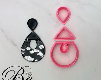May include: A set of three pink polymer clay earring cutters. The cutters are shaped like a teardrop, a triangle, and a circle with a teardrop inside. The cutters are used to create earrings with a unique geometric design.