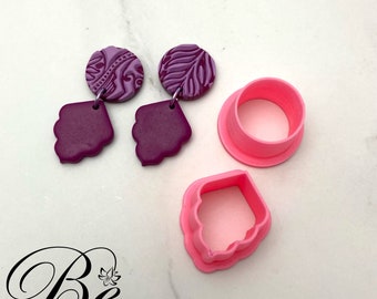 Peut inclure: Un ensemble de trois emporte-pièces en argile polymère rose, deux sont en forme de larme avec un bord festonné et un est un cercle. Il y a aussi deux paires de boucles d'oreilles, une paire est violette avec un motif floral et l'autre paire est une forme de larme violette unie.