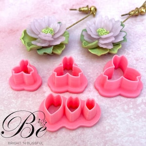 Peut inclure: Ensemble d'emporte-pièces en plastique rose pour l'artisanat et la décoration. Les emporte-pièces sont en forme de fleur à trois pétales, d'une feuille et d'un cœur.