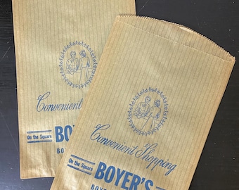 May include: Two tan paper bags with vertical ribbed texture. Each bag features blue text and a circular illustration. The text reads "Convenient Shopping" and "BOYER'S BOYERTOWN, PA. Since 1805."