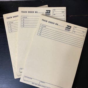 May include: Three blank train order forms with the Burlington Northern logo. The forms have fields for location, date, time, and operator.