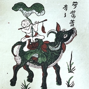 Può includere: Un'illustrazione colorata raffigura un bambino che suona il flauto mentre cavalca un bufalo d'acqua. Il bufalo è verde scuro con dettagli rossi e bianchi. Il bambino è bianco con dettagli rossi. L'immagine ha del testo in alto a destra.