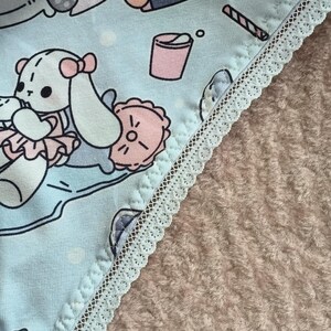 May include: Light blue underwear with a white lace trim and a cartoon animal print. The print features a variety of animals, including a dog, a cat, and a rabbit. The underwear has a light blue background with white polka dots.