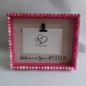 May include: Pink picture frame with a beaded border and the text "Believe in Your #SELFIE".