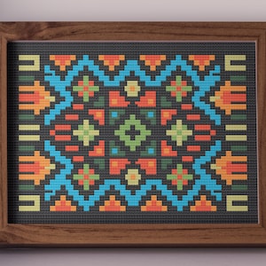 Könnte beinhalten: Ein gerahmtes Kreuzstichstück mit einem geometrischen Design. Das Kunstwerk zeigt einen dunkelgrauen Hintergrund mit einem Muster aus orangefarbenen, blauen, grünen und gelben Formen. Der Rahmen ist aus dunklem Holz.