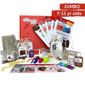 May include: A red "The Curiosity Box" kit for ages 7-11, containing ingredients and instructions for a science experiment. Includes packets of flour, sugar, and cocoa nibs, plus measuring spoons and a bottle of golden syrup.
