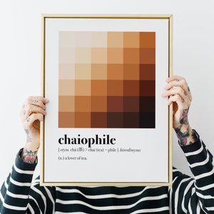 May include: A framed print with a brown and beige colour palette, featuring the word "chaiophile" defined as "a lover of tea".