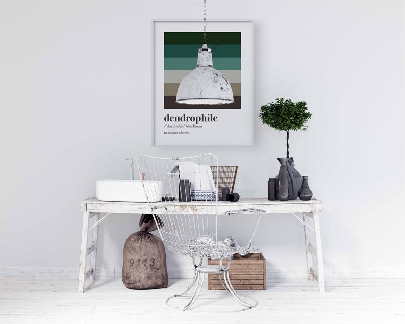 Pu&ograve; includere: Un tavolo in legno sbiancato con una sedia in metallo bianco, un lavandino in ceramica bianca, un sacco di juta marrone e una stampa incorniciata con la parola "dendrofilo" e uno schema di colori verde, marrone e bianco.