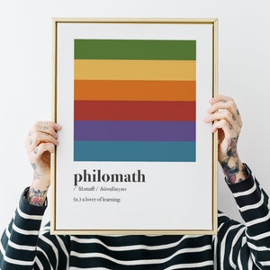 Puede incluir: Una impresión enmarcada con un diseño de rayas coloridas y la palabra "philomath" definida como "un amante del aprendizaje".