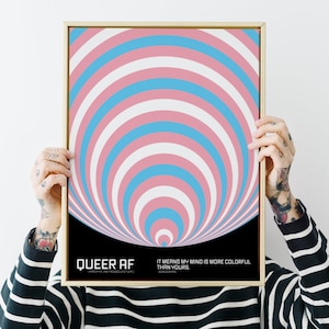 Puede incluir: Una impresión enmarcada con fondo negro y un diseño colorido y giratorio en rosa, azul y blanco. El texto "QUEER AF" está en la parte inferior izquierda, y el texto "IT MEANS MY MIND IS MORE COLORFUL THAN YOURS." está en la parte inferior derecha.