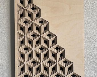 May include: A wooden wall art piece with a geometric design of overlapping cubes. The cubes are cut out of the wood, creating a 3D effect. The piece is made of light wood and has a natural finish.
