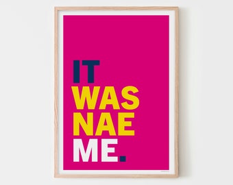 May include: A framed print with a pink background and the text "IT WAS NAE ME." in yellow and blue.