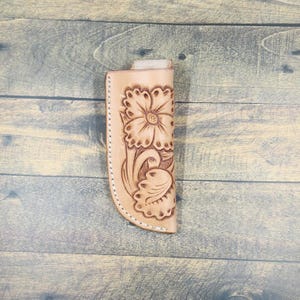 Hand tooled leather knife sheath with a floral design.