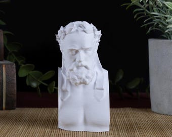 May include: A white matte bust sculpture of a bearded man wearing a laurel wreath on his head. The figure is depicted from the chest up, featuring detailed facial hair, a defined nose, and a classic, smooth finish on the surface of the material.