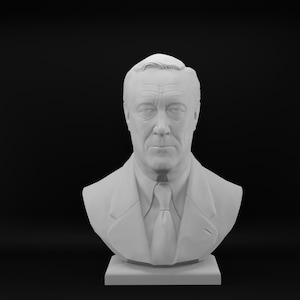 May include: A matte white bust sculpture depicting a person with short hair, wearing a collared shirt and a necktie. The figure is shown from the chest up, featuring detailed facial features including eyes, a nose, and a mouth, set on a square base.