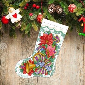 May include: A white Christmas stocking with a green and white border. The stocking is decorated with a red poinsettia, a gold bell, and a purple and white ribbon. The stocking is on a wooden background.