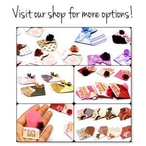 May include: A selection of small, handmade paper envelopes with a variety of designs and colours. Some envelopes feature floral embellishments, while others have patterned paper or text. The envelopes are ideal for adding a touch of whimsy to gifts, cards, or other special occasions.