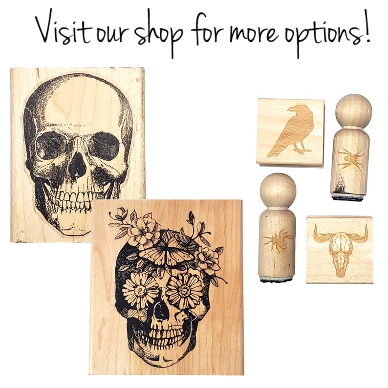 May include: A collection of wooden stamps featuring designs such as skulls, a raven, a spider, and a bull skull. The stamps are made of light wood and have black ink designs. The text "Visit our shop for more options!" is at the top.