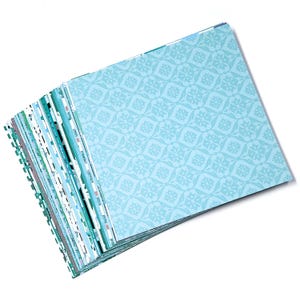 May include: A stack of light blue patterned paper with a white design. The paper is folded in half and has a decorative edge.