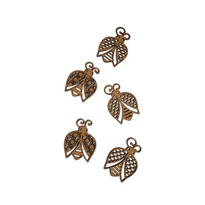 May include: Five wooden cutout bees with intricate designs. The bees are brown and have a white center. They are arranged in a random pattern on a white background.