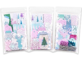 May include: Three clear plastic bags filled with assorted winter-themed paper cutouts, including light blue and pink deer silhouettes, mason jar shapes, snowflake designs, evergreen trees, and small containers of silver, pink, and blue beads.