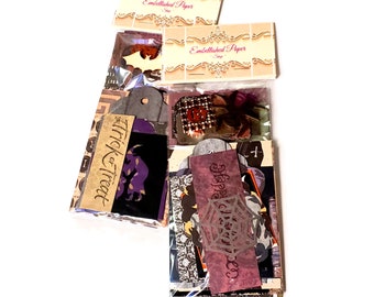 May include: A package of Halloween themed paper crafting supplies. The package includes various paper tags, embellishments, and patterned paper. The tags feature the text "Trick or Treat" and "Happy Halloween".