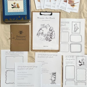 Puede incluir: Una colección de artículos con temática de Winnie the Pooh, que incluye un libro de tapa dura azul, un diario marrón y varias hojas impresas con ilustraciones y texto. Los artículos están dispuestos sobre una superficie de color claro, creando un tema educativo cohesivo.