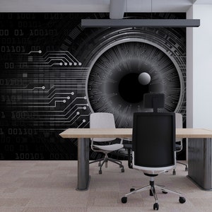 May include: A black and white digital eye graphic with circuit board patterns on a wall behind a desk with a black office chair and a white office chair.
