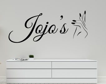 May include: Black and white vinyl decal with the text "Jojo's" in a cursive font and a stylized image of a hand with manicured nails.