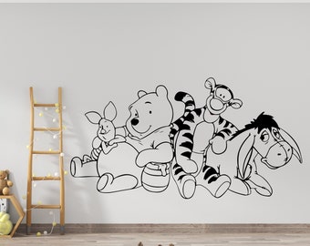 May include: Black and white line art wall decal featuring Winnie the Pooh, Piglet, Tigger, and Eeyore. The characters are arranged in a playful group, with Winnie the Pooh holding a pot of honey.