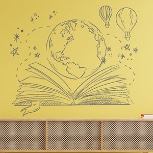 Puede incluir: Una pared amarilla con una ilustraci&oacute;n dibujada a mano de un libro abierto, un globo terr&aacute;queo y dos globos aerost&aacute;ticos. El libro est&aacute; abierto y tiene un marcap&aacute;ginas de cinta. El globo terr&aacute;queo est&aacute; en el centro de la imagen y est&aacute; rodeado de estrellas. Los globos aerost&aacute;ticos est&aacute;n en la esquina superior derecha de la imagen. La pared est&aacute; decorada con una estanter&iacute;a de madera con un libro rojo en la parte superior.