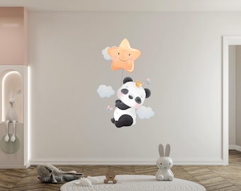 May include: A black and white panda bear wearing a crown is holding onto a yellow star balloon with a smiling face. The panda is floating in the air with white clouds behind it.