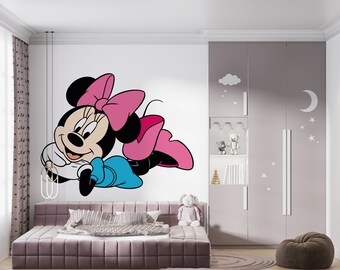 May include: A white wall with a cartoon image of Minnie Mouse in a pink bow and blue dress. The wall is decorated with a white cloud and stars. A pink closet with a white moon and stars is in the background.
