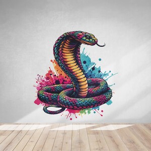 Könnte beinhalten: Eine farbenfrohe Illustration einer Kobra mit erhobener Haube, umgeben von abstrakten Aquarell-Farbklecksen in Rosa-, Blau-, Grün- und Gelbtönen.